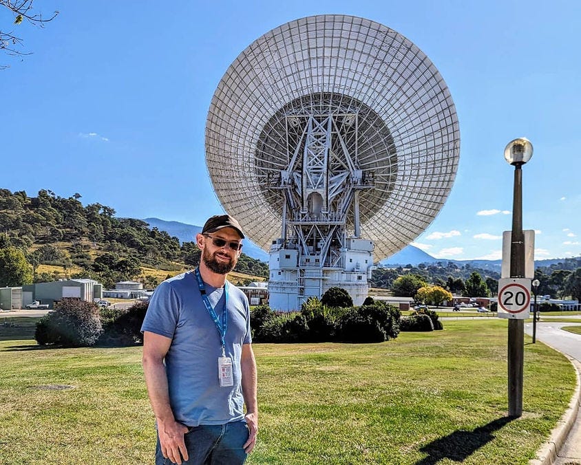 Michael Plis standing next to Deep Space Station 43 in Canberra
