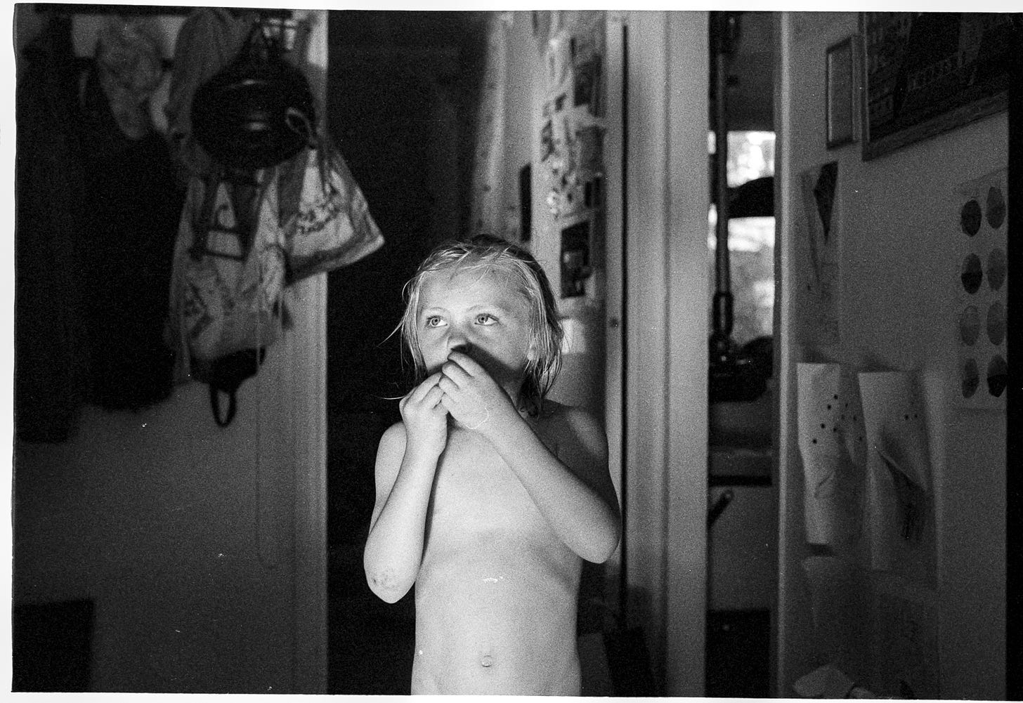 Boy picks his nose inside a house. Boy picks his nose inside a house.