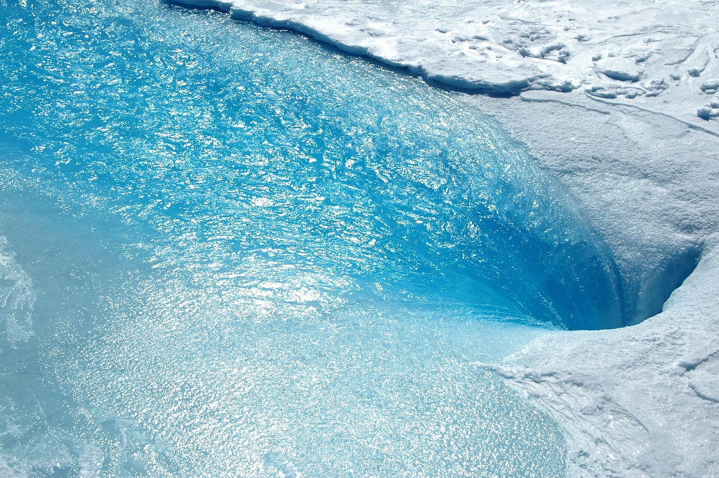 Meltwater pouring into a moulin on Greenland
