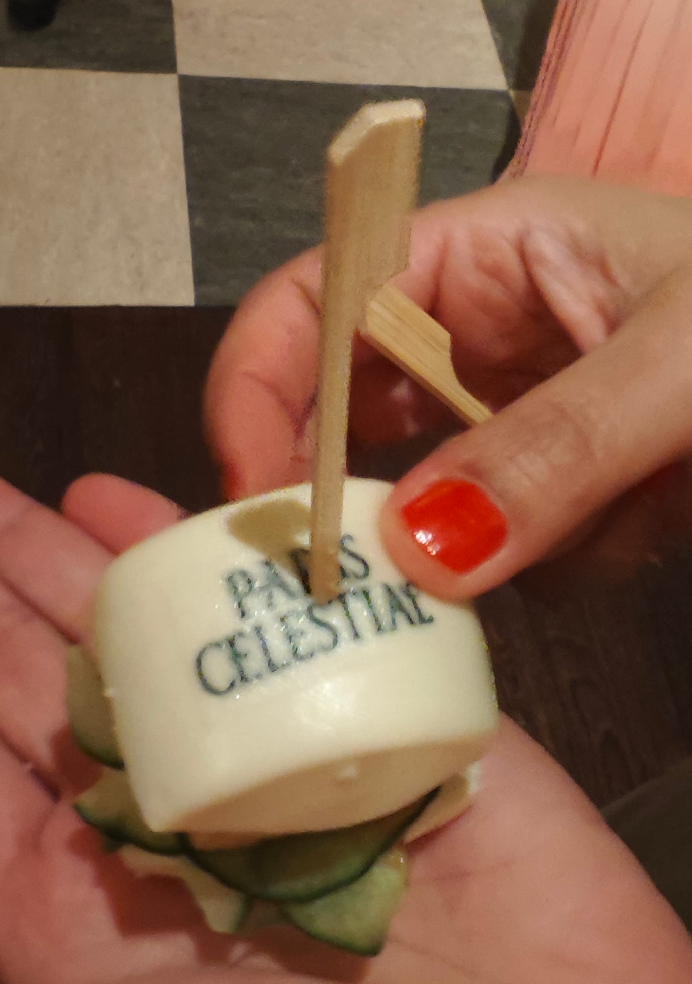 A person holding a small white object with a wooden stick

AI-generated content may be incorrect.