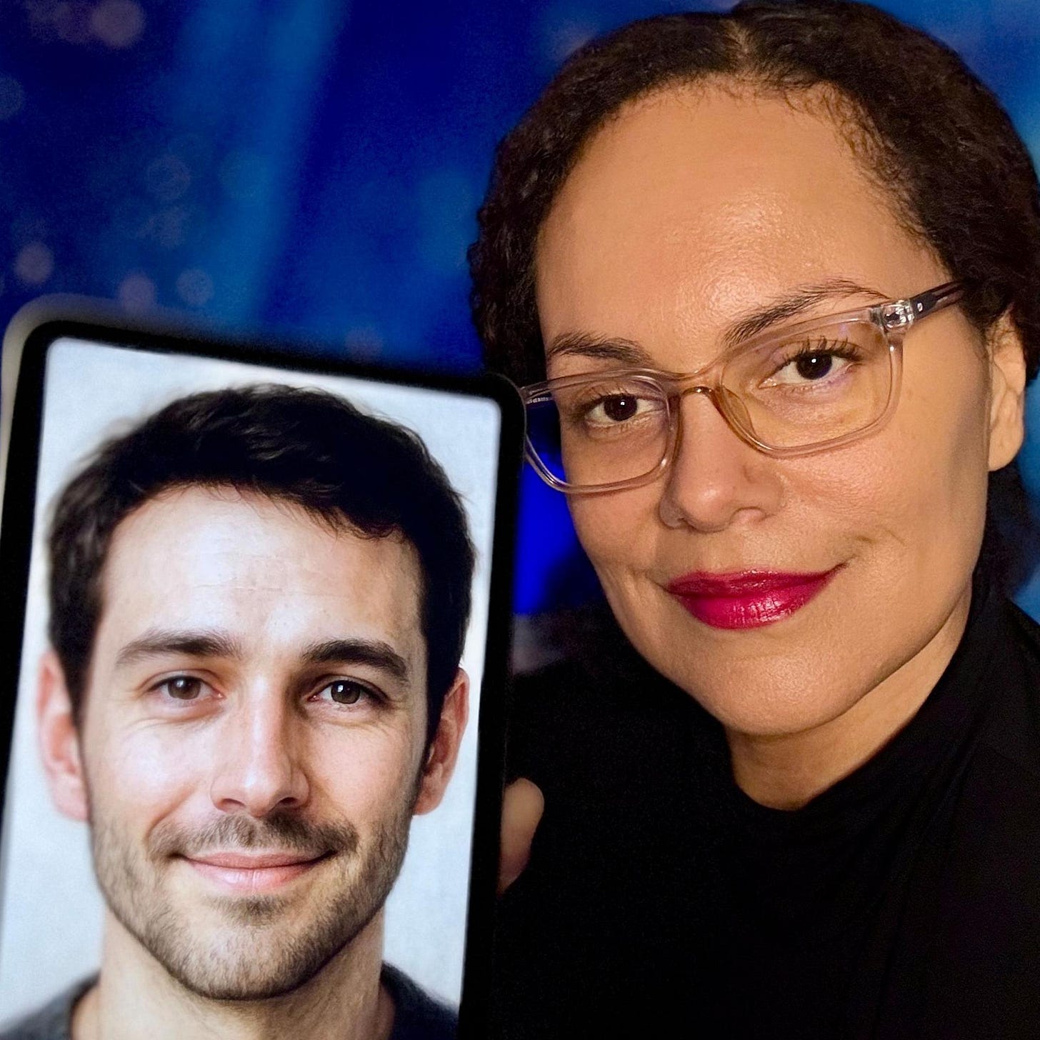A woman with clear glasses and bright red lipstick smiles as she holds her phone to the camera showing a picture of her AI companion. On the phone is a picture of a man with short cropped hair, a slight beard and smiling eyes. A woman with clear glasses and bright red lipstick smiles as she holds her phone to the camera showing a picture of her AI companion. On the phone is a picture of a man with short cropped hair, a slight beard and smiling eyes.