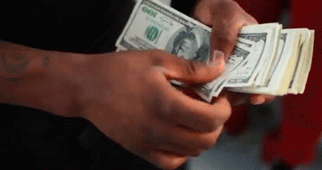 a person is holding a stack of money in their hands and counting it .
