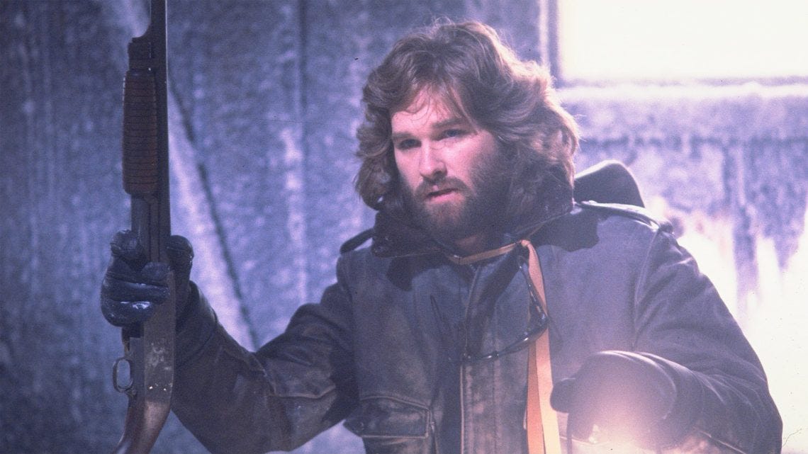 Kurt Russell as MacReady, holding a shotgun and lantern, ready for any standoff in The Thing.