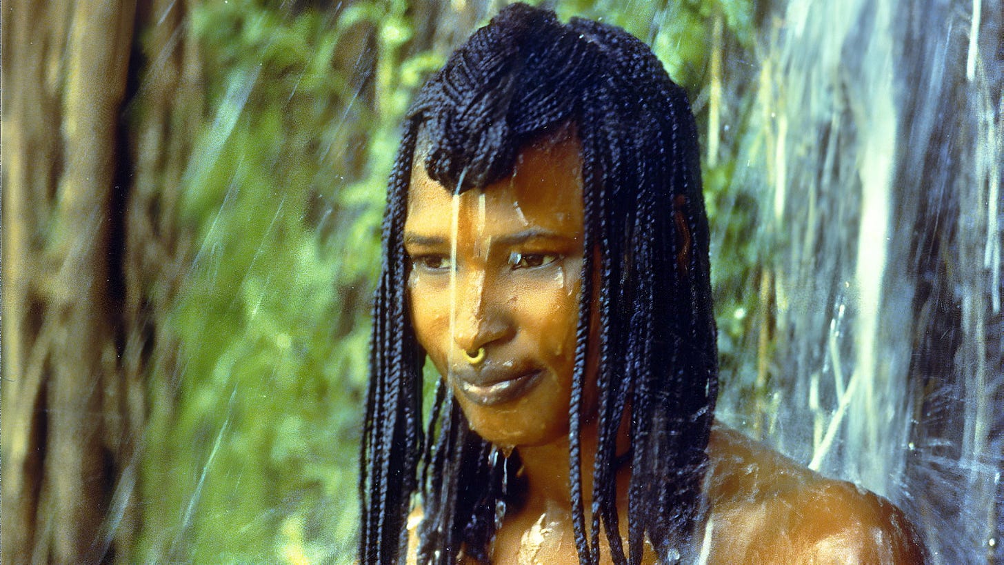 Yeelen | Still features a young African woman bathing under a waterfall.