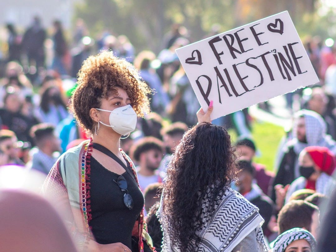 woman in black and white long sleeve shirt holding white and blue signage