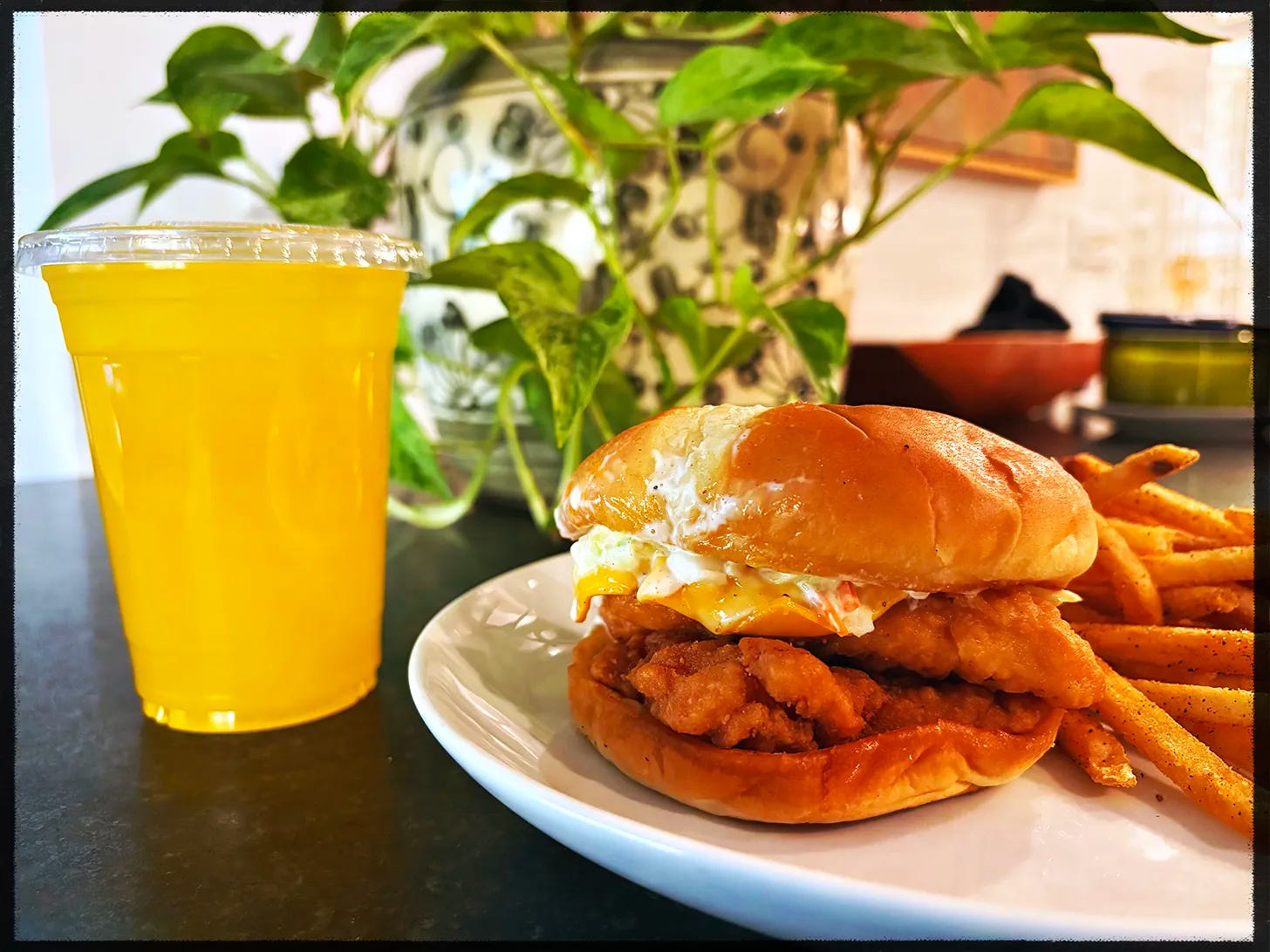 A mango juice and a chicken sandwich. A mango juice and a chicken sandwich.