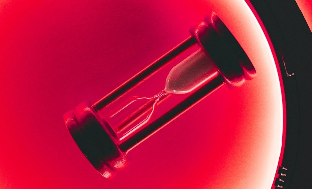 clear hour glass with red background