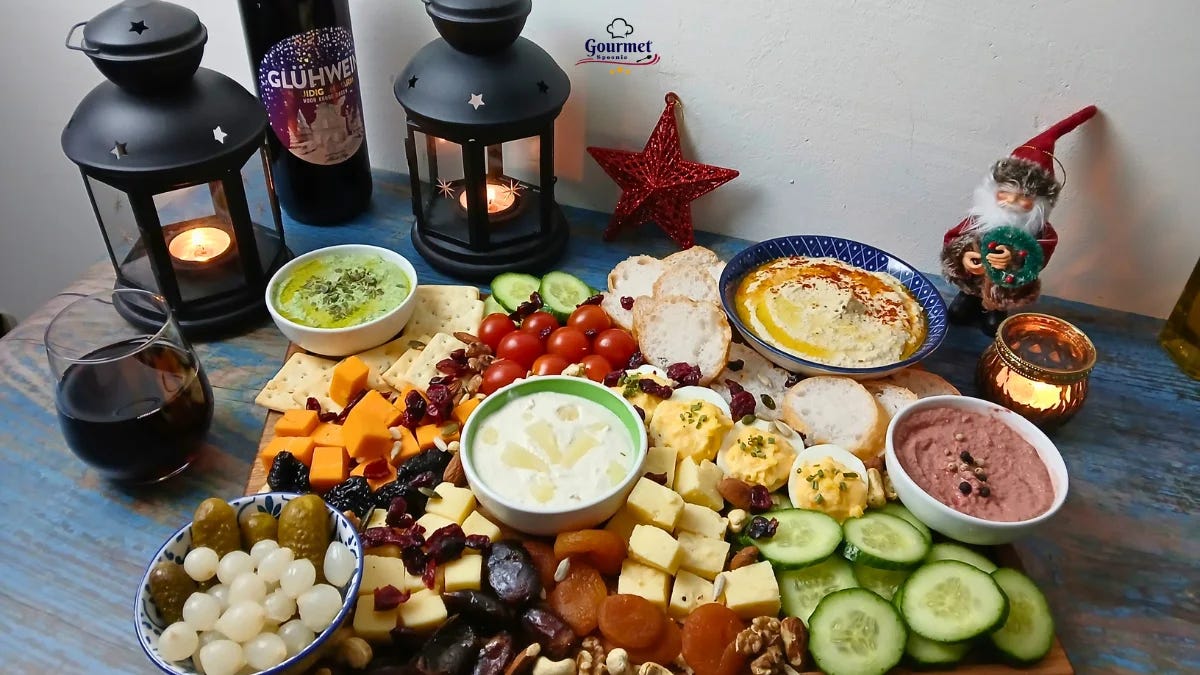 A festive Christmas grazing board with candles, wine, cheese, crackers, dips, pickles, dates, nuts, cherry tomatoes, cucumber slices, and a small Christmas gnome sets the scene for a joyful holiday celebration.