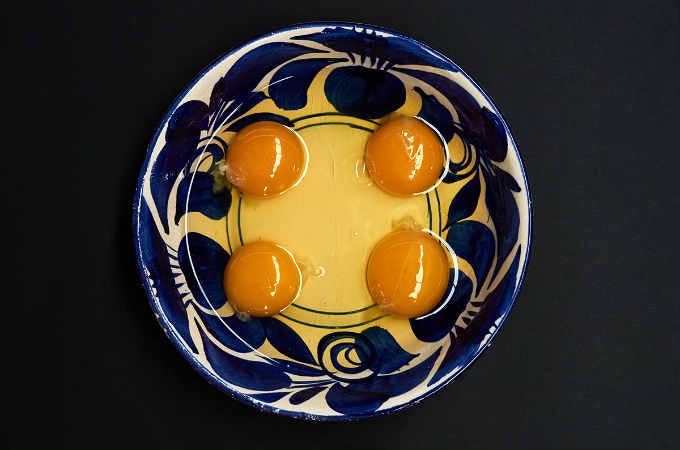 four cracked eggs in bowl