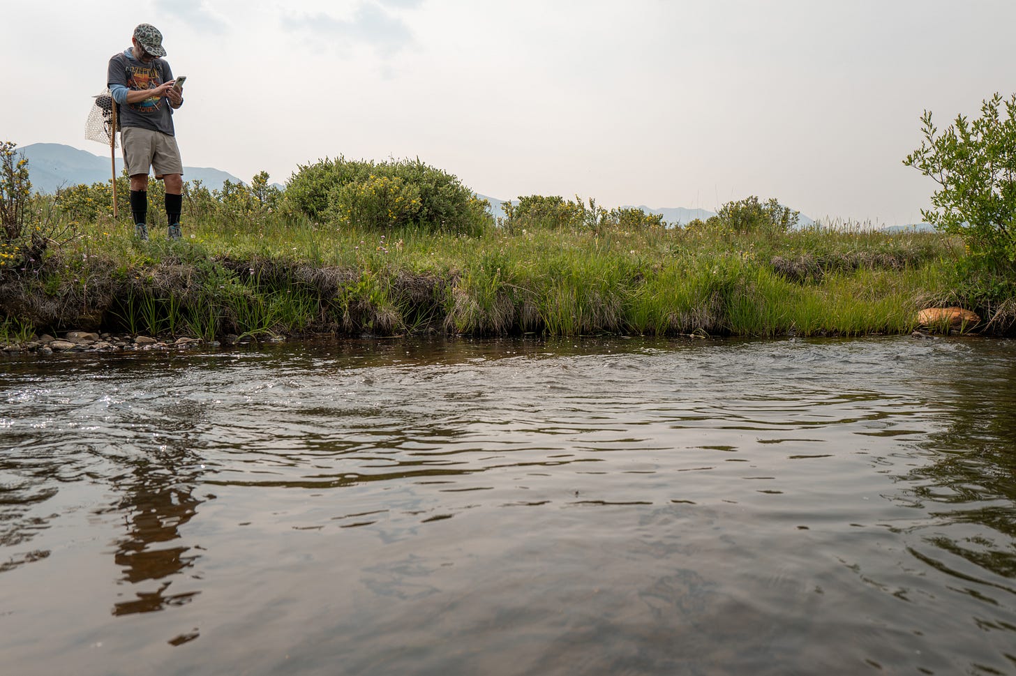 Flylab founder Andrew Steketee, checking his phone on the river.