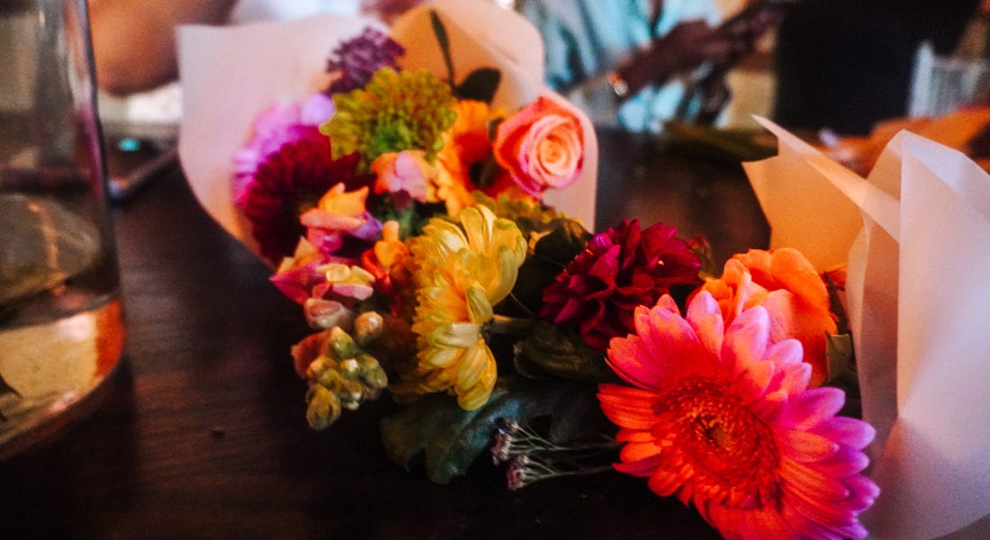 Two wrapped bouquets of flowers on a wooden table Two wrapped bouquets of flowers on a wooden table