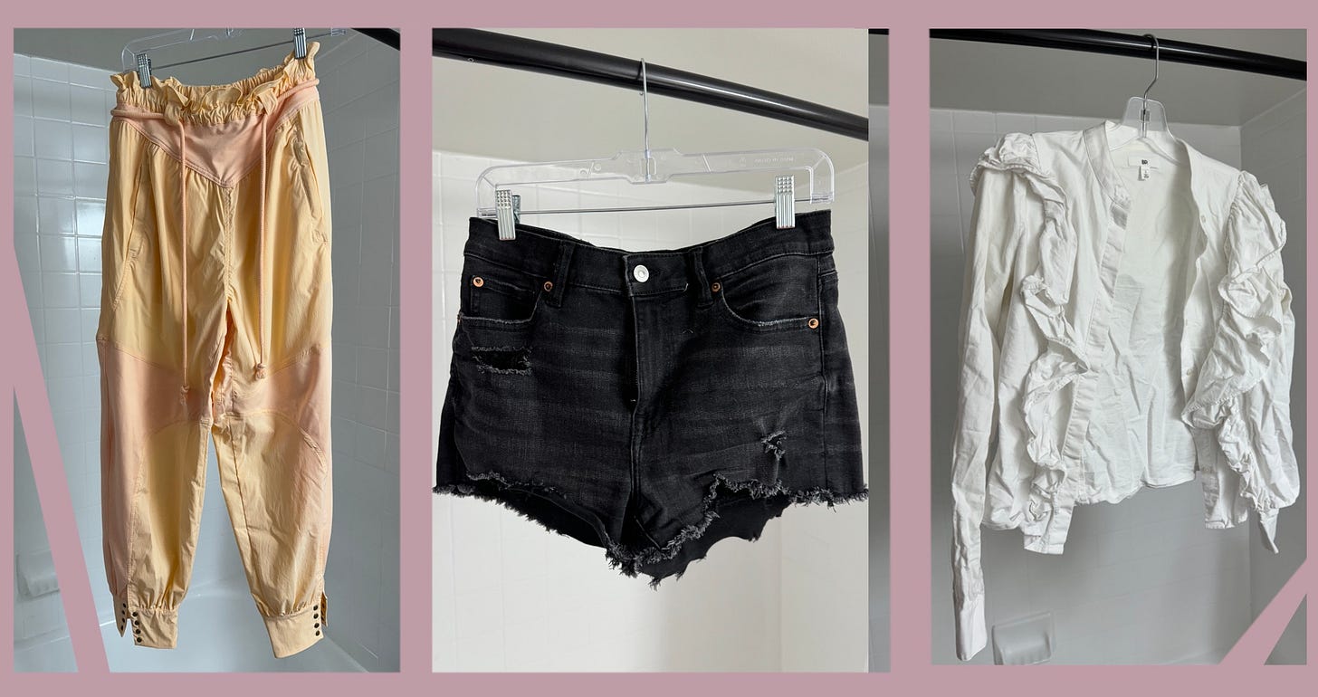 A collection of three items; a pair of athleisure capris in pink, a pair of black denim shorts, and a white shirt with ruffles.