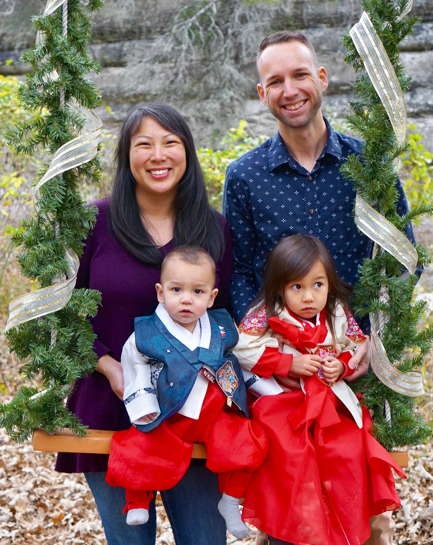Middle-aged Korean woman standing next to White male, two adorable multiracial children in front Middle-aged Korean woman standing next to White male, two adorable multiracial children in front