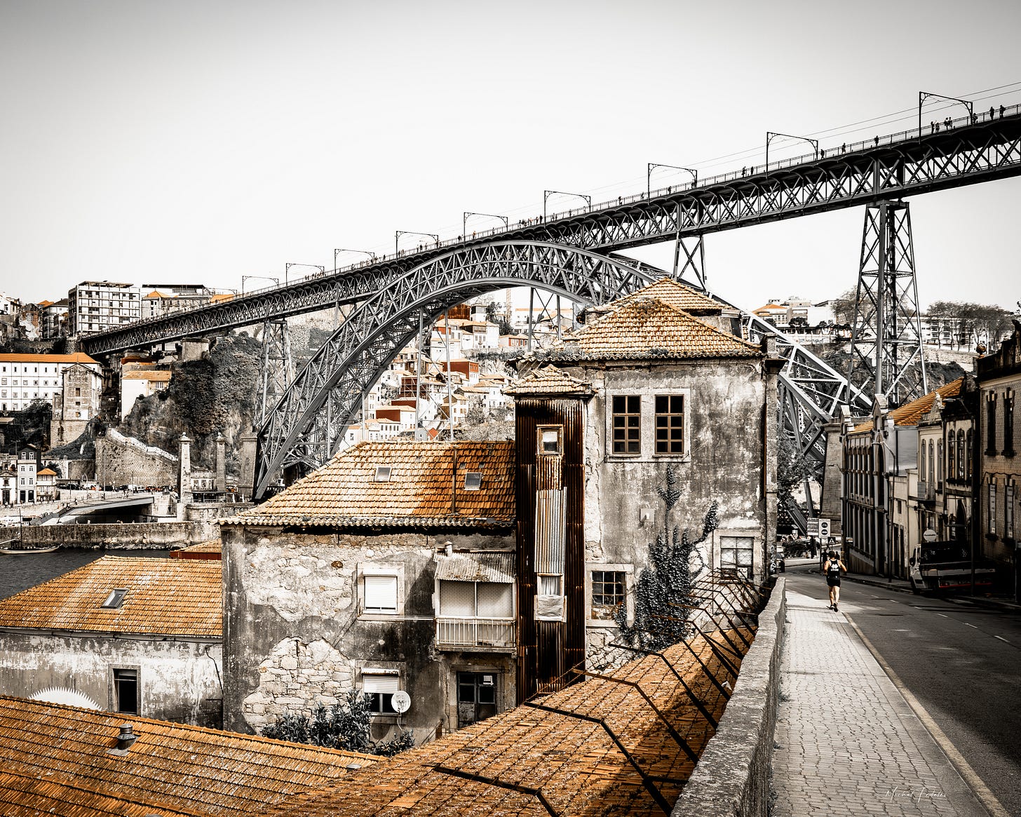 A view of an old town road and a bridge across the Douro river in Porto, Portugal
