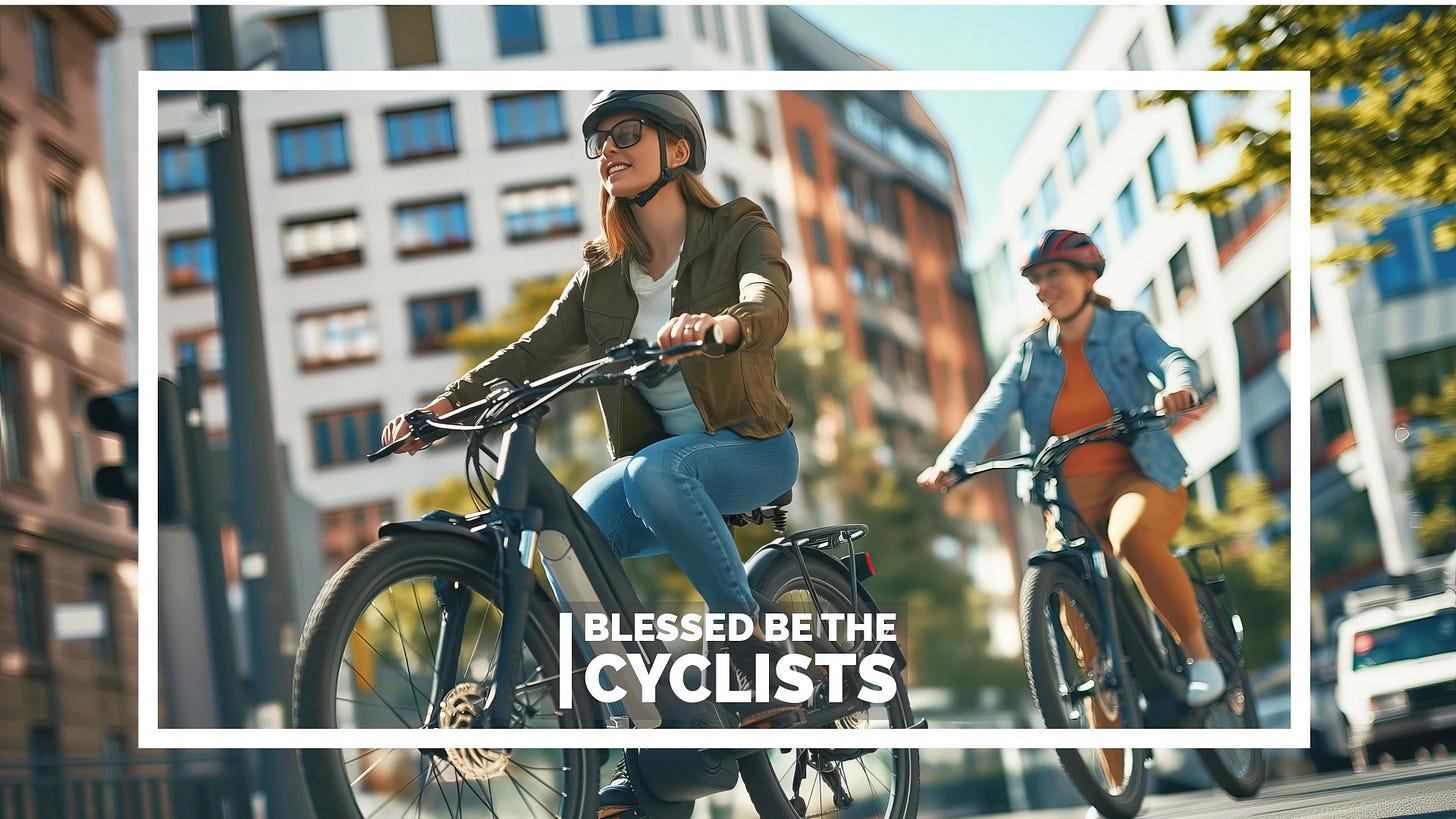 Two women cycling in the city with the caption “Blessed be the cyclists”