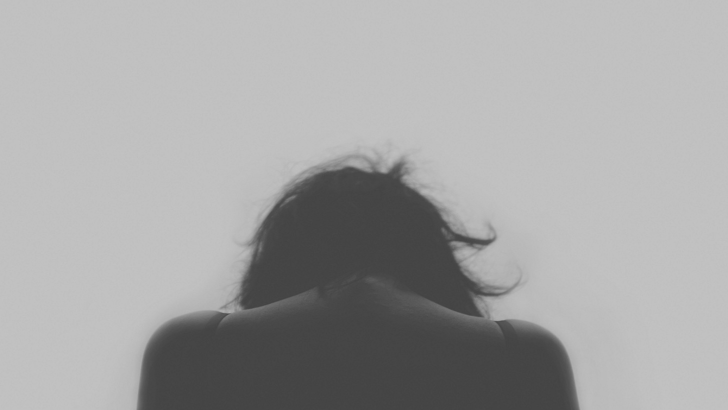 A woman with her head hunched over and shoulder slouching over too much pressure A woman with her head hunched over and shoulder slouching over too much pressure