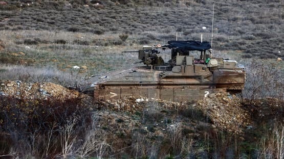 Israeli soldiers rides in an APC in Syria, near the ceasefire line between the Israeli-occupied Golan Heights and Syria, as seen from Majdal Shams in the Israeli-occupied Golan Heights, December 25, 2024. REUTERS/Jamal Awad