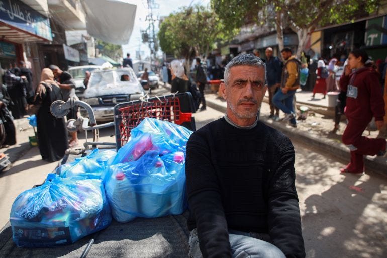Hani Abu Issa went to the market to stockpile some goods upon hearing the news of Iran’s war [Abdelhakim Abu Riash/ Al Jazeera]