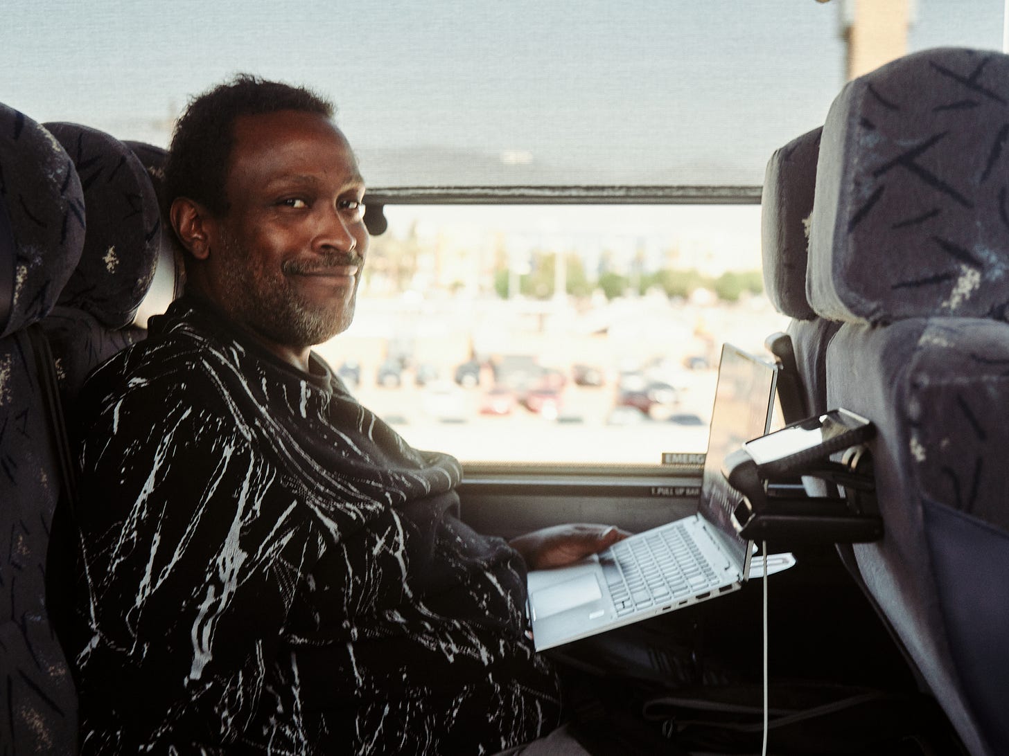 Portrait of a man working on his laptop inside the Harris Walz campaign bus on its way to Phoenix, AZ, by LA photographer Afonso Salcedo