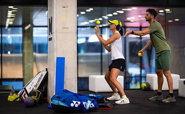 Iga Swiatek of Poland warms up before playing against Alexandra Eala of the Philippines in the second round on Day Three of the Mutua Madrid Open at...