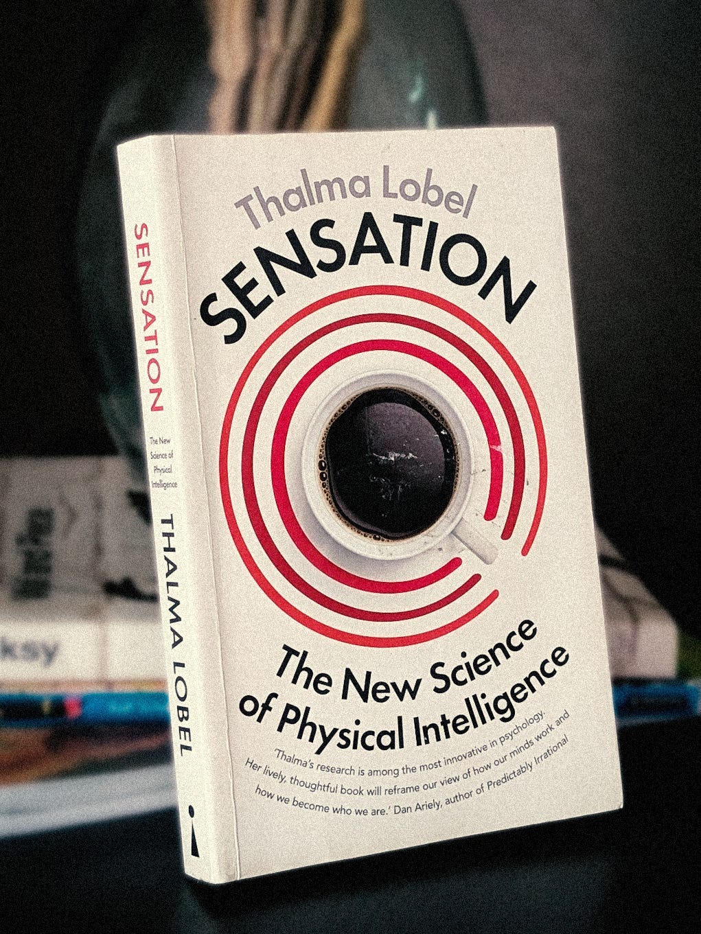 A book. White cover, with a coffee cup shot from above, in the middle.  On the top side of the cover, above the cup, it says: Thalma Lobel Sensation At the bottom it says: The New Science of Physical Intelligence.