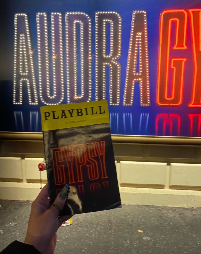 The GYPSY Playbill held up to AUDRA's marquee