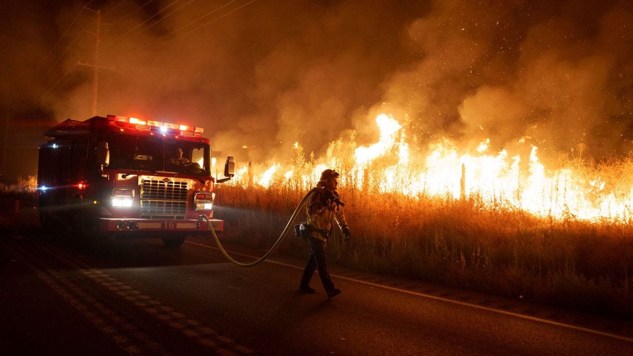 A firefighter watches flames from the Rabbit Fire approach Gilman Springs Road late Friday, July 14, 2023, in Moreno Valley.