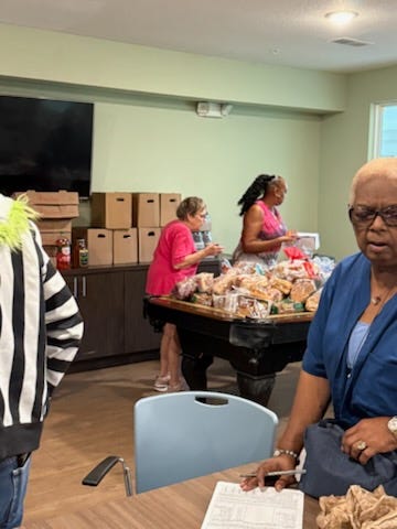Citizens helping distribute food from a table and a truck trailer