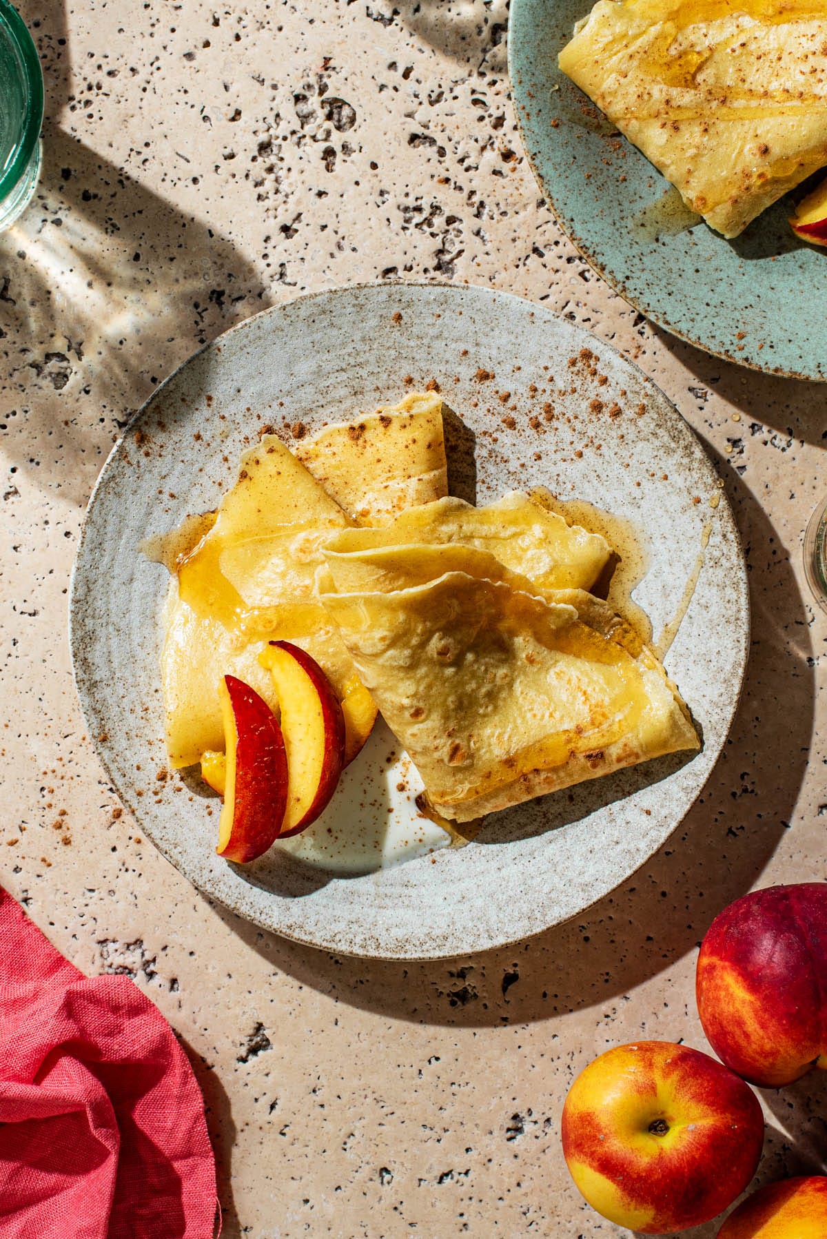Two pancakes folded into triangles on a plate with toppings.
