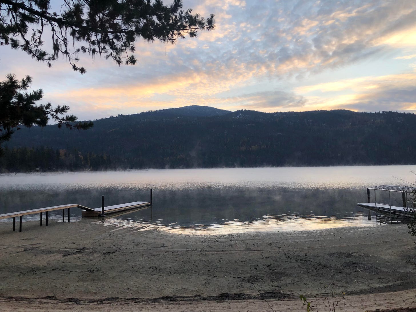 water, hills, a tree, two docks at Priest Lake, Idaho