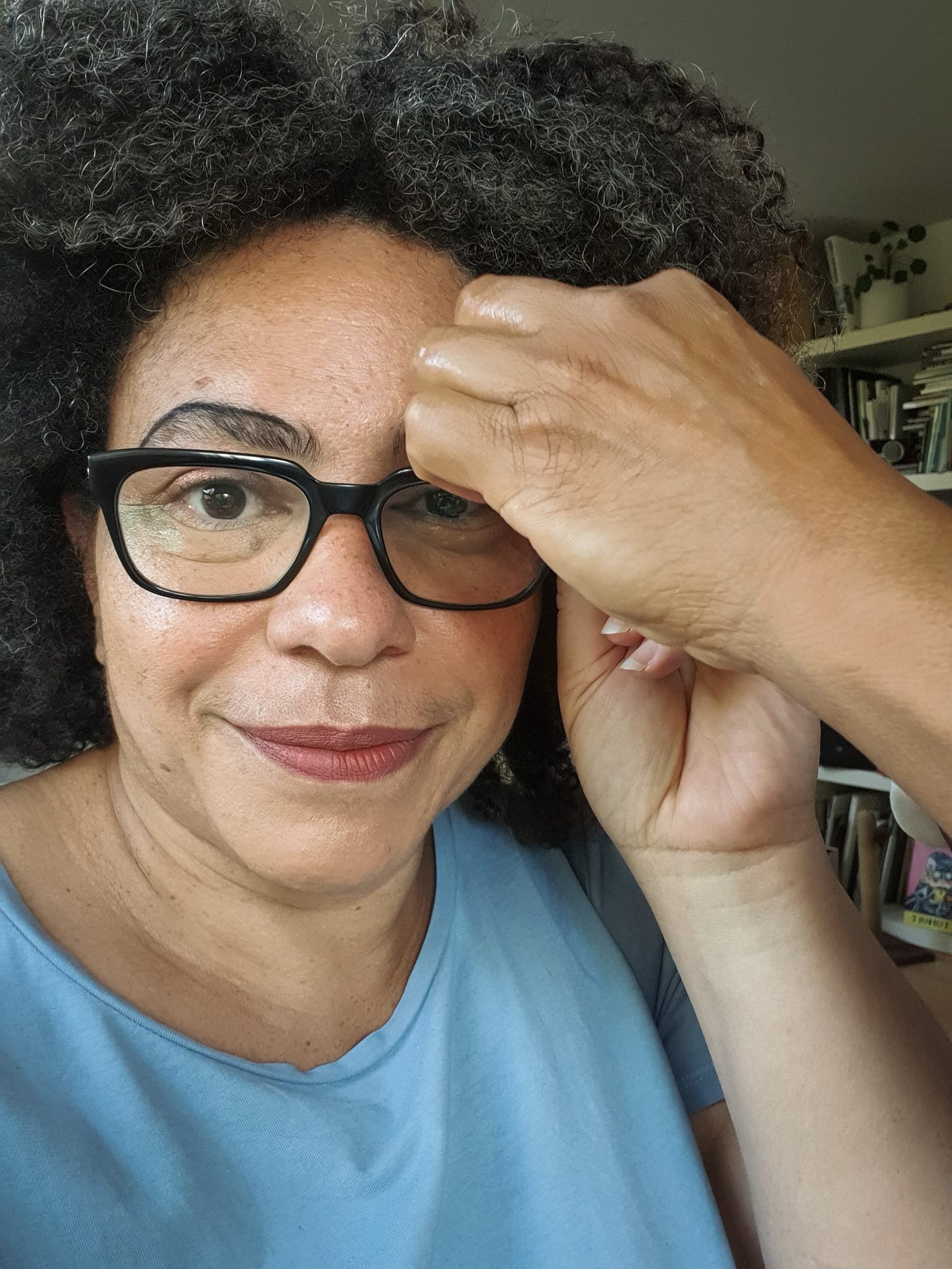 Photo of a woman's face having makeup applied to her eyebrows