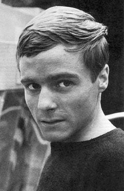 Serious young man head and shoulders, woman and man sitting onstone wall