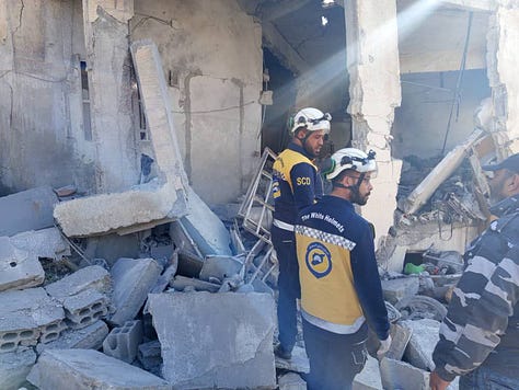 Beit Jinn in the immediate aftermath of the strike — homes torn open, streets covered in debris, and White Helmet rescuers searching for survivors beneath collapsed structures.