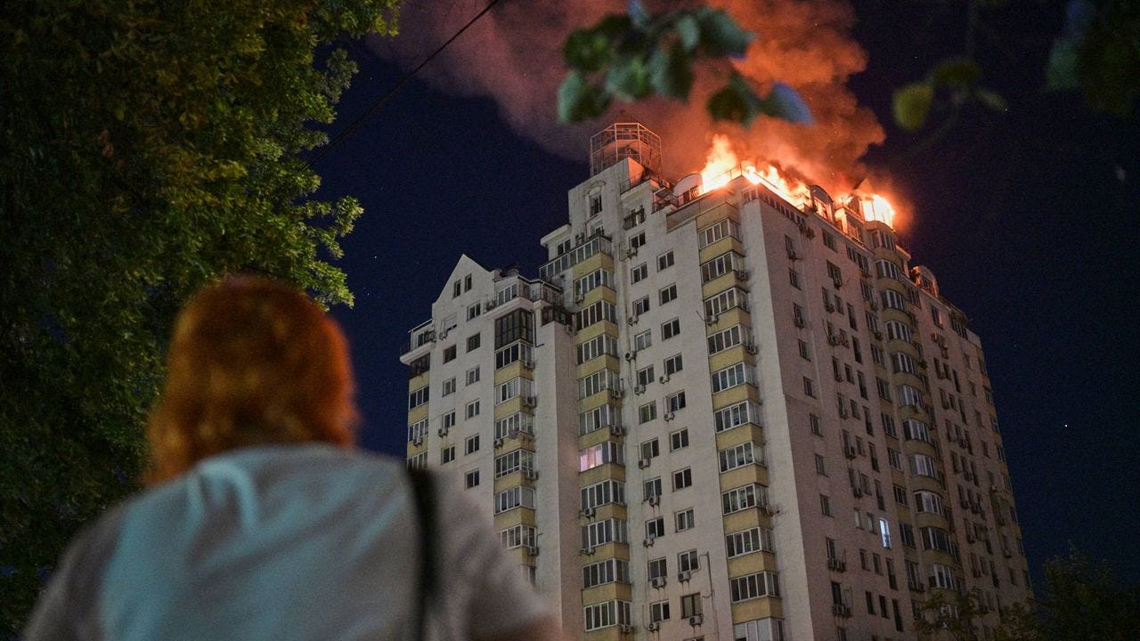 A woman looks at an apartment building burning after a Russian missile attack in Kyiv, Ukraine, Thursday, July 2, 2026. (AP Photo/Danylo Antoniuk)