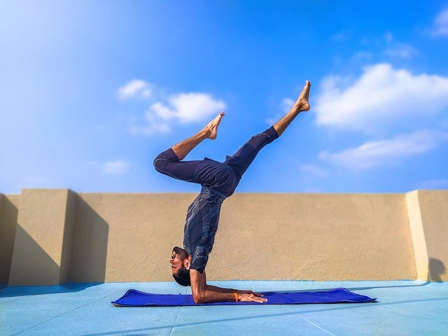 An impossibly fit man does a complicated yoga pose on a Saturday morning on a beautiful terrace An impossibly fit man does a complicated yoga pose on a Saturday morning on a beautiful terrace