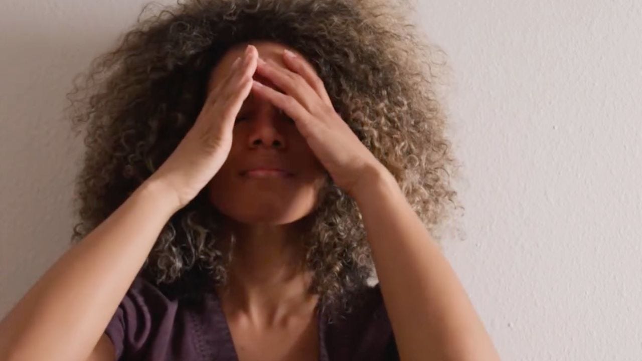 woman holding hands over her face