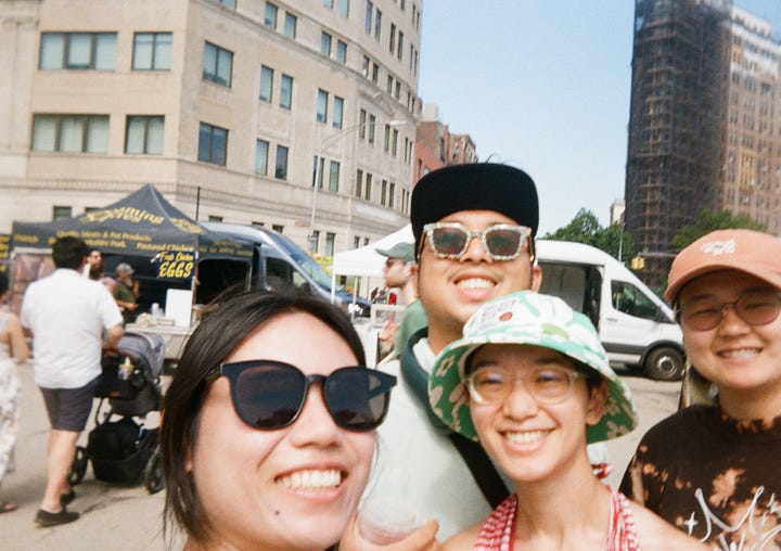 Photo 1: Canoers on the Gowanus Canal, Photo 2: Selfie of the author and friends at the farmer's market, Photo 3: Assortment of flowers on sale at the farmers market, Photo 4: New York skyline taken from a ferry taken in the day, slightly overexposed and hazy