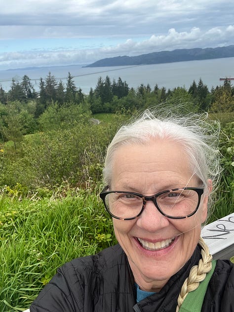 1. Tugboat going under a bridge at sunset. 2. Freighter on the Columbia River. 3. Astoria-Megler Bridger in sunrise. 4. Ships on the Columbia River with pilings. 5. Binoculars. 6. Big ship on the Columbia River. 7. View of the Columbia and Pacific Ocean from the Astoria Column. 8. Photo of Rose smiling from the Astoria Column. 9. View of downtown Astoria and the Columbia River