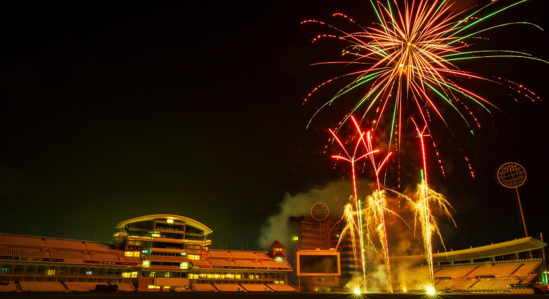 A cricket ground with a night sky with colourful fireworks A cricket ground with a night sky with colourful fireworks