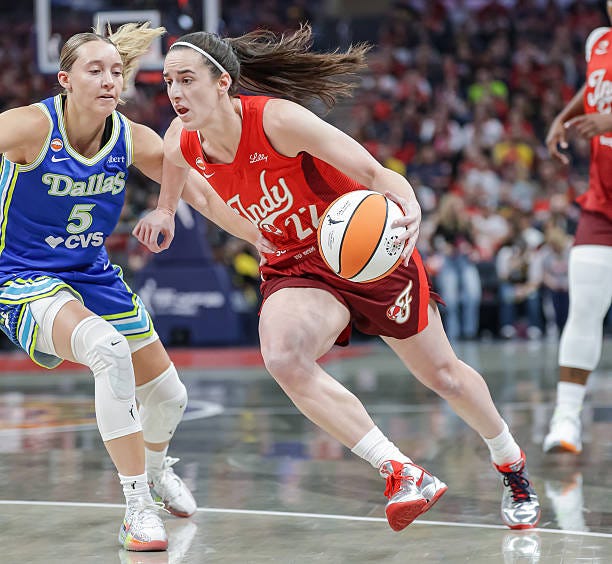 Caitlin Clark of the Indiana Fever dribbles the ball against Paige Bueckers of the Dallas Wings during the first half at Gainbridge Fieldhouse on May...