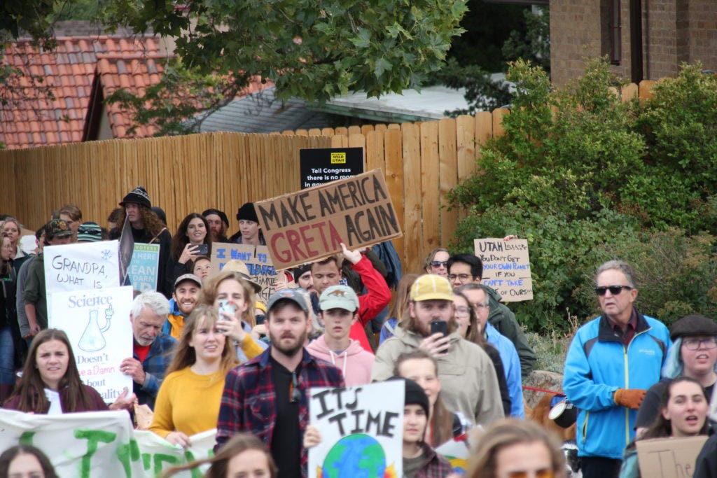 A marcher holds a sign that says "Make America Greta Again." A marcher holds a sign that says "Make America Greta Again."