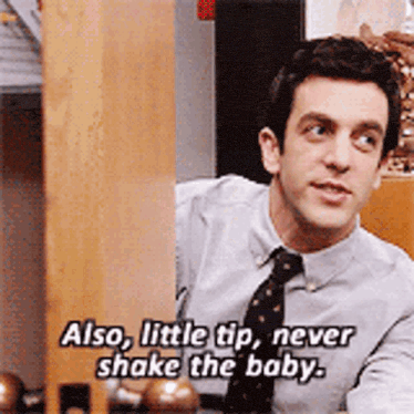 a man in a shirt and tie is talking about shaking the baby .