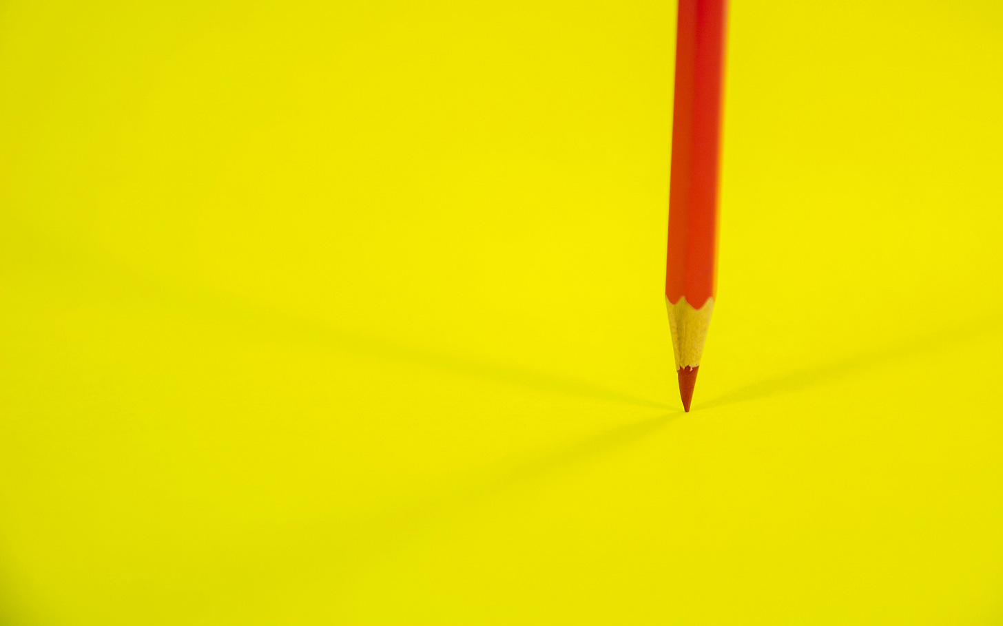 Red pencil on a yellow background.