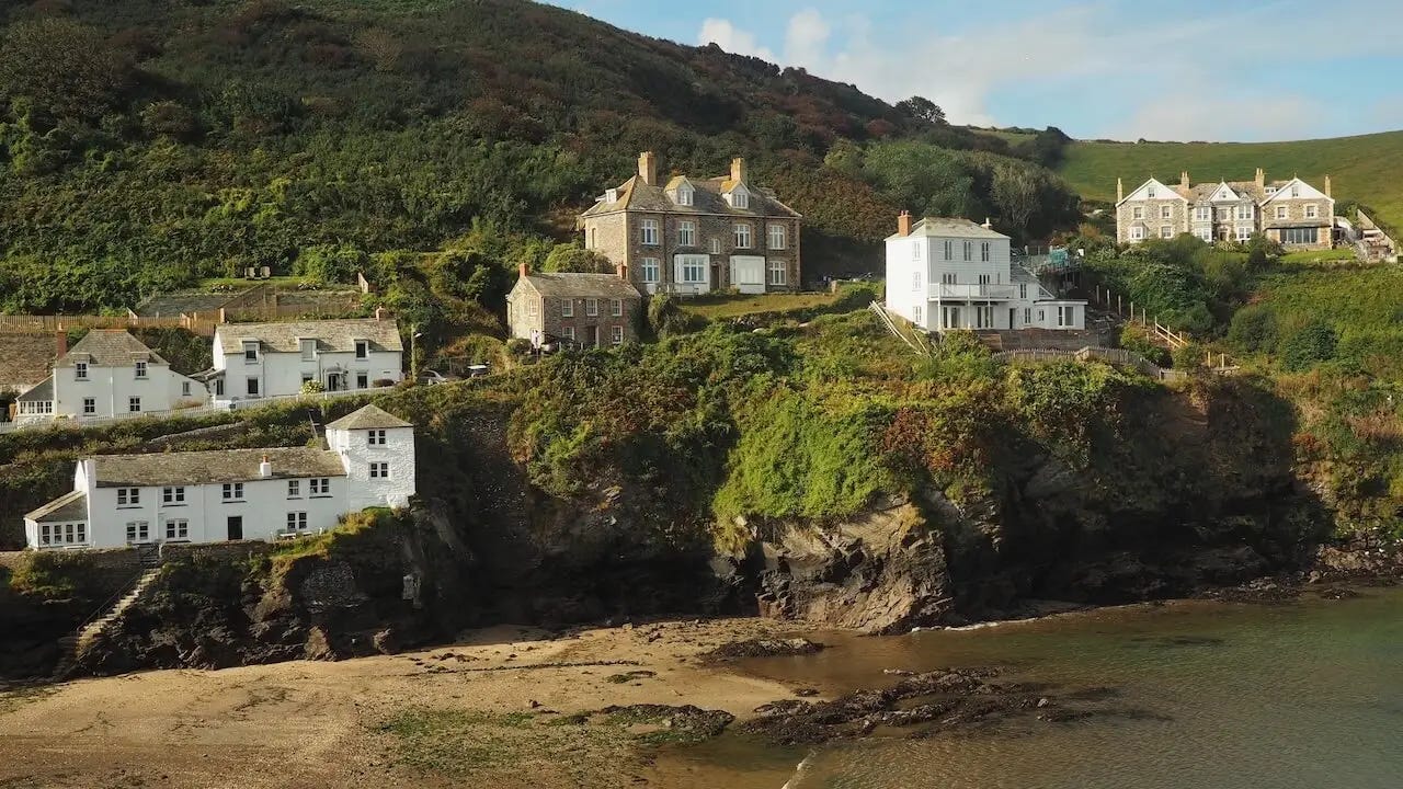White cottages overlook cliffs to a sandy beach
