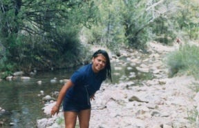 A young girl is standing in the water.