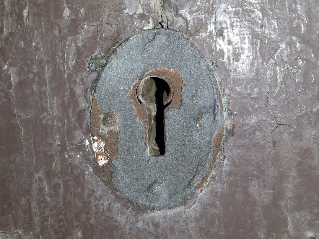 a door with a keyhole in the middle of it a door with a keyhole in the middle of it