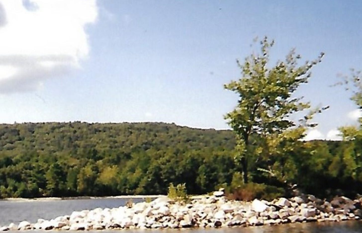 A New England lake with a forested hill beyond