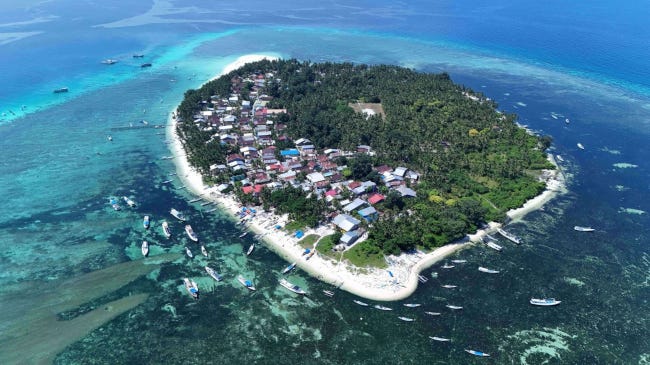 Une île paradisiaque en Indonésie, en vue aérienne, cernées par des eaux turquoise Une île paradisiaque en Indonésie, en vue aérienne, cernées par des eaux turquoise