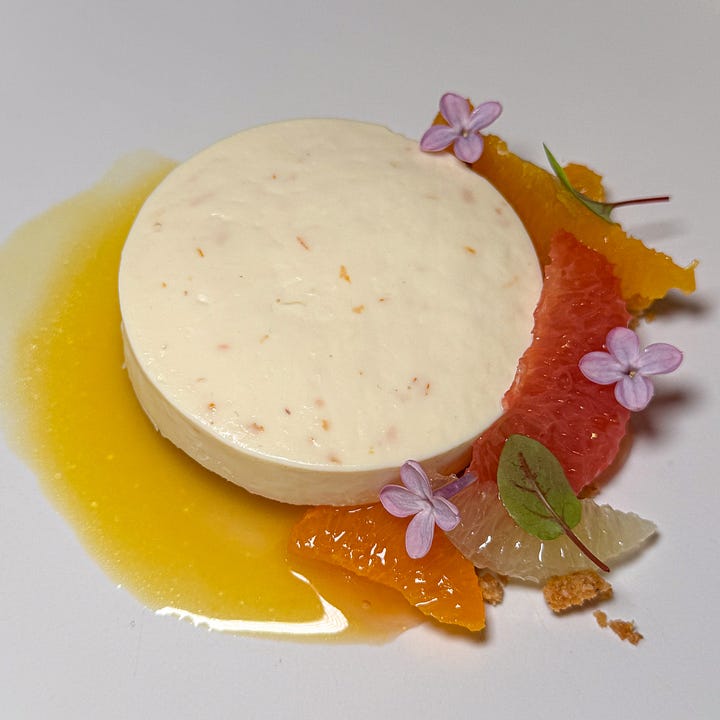 Citrus-and-fennel mousse ringed with orange and grapefruit segments and purple blossoms and Chocolate mousse in a chocolate tuile cup, capped with a thin chocolate wafer, in caramel