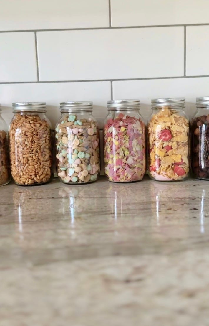 A variety of different homemade cereals in large glass jars.